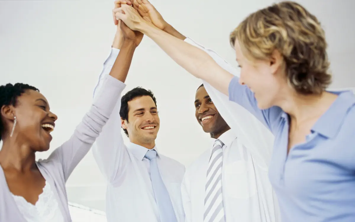 A business team celebrating a successful project with a high five